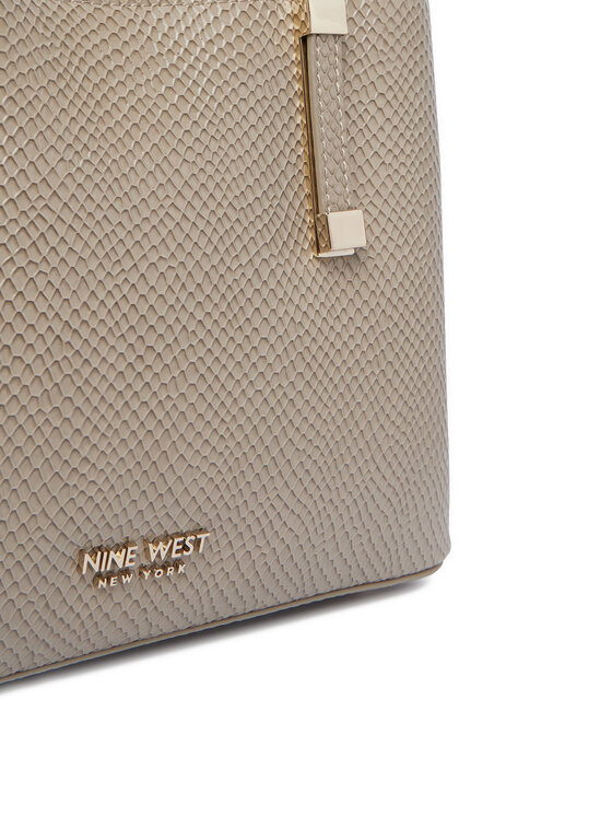 Zbliżenie na dolną część torebki z widocznym detalem mocowania uchwytu.