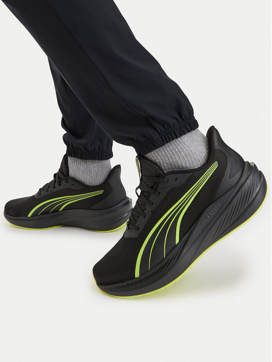 Model prezentujący buty sportowe na stopach, ujęcie z góry na nogi.