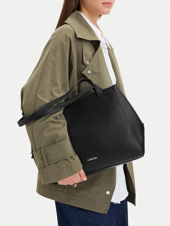 Modelka prezentująca torebkę shopper, trzymaną na przedramieniu.