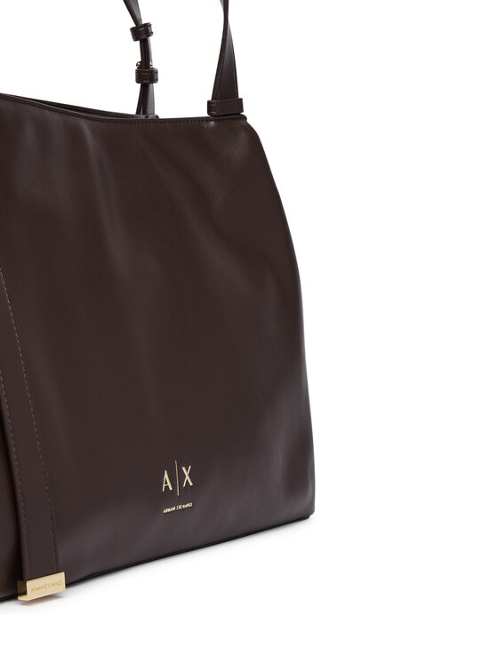 Zbliżenie na dolną część torebki z widocznym fragmentem uchwytu.