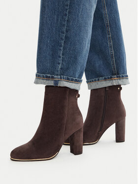 Modelka w dżinsach prezentująca botki na obcasie, ujęcie bokiem całych butów.